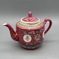 Left side view of pink Chinese porcelain teapot with longevity medallions and lid