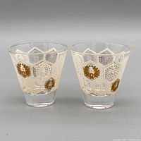 Front view of both 3oz hexagon-pattern gold laurel glasses