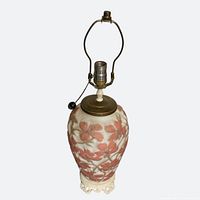 Full lamp with harp attached showing floral ceramic body and brass hardware