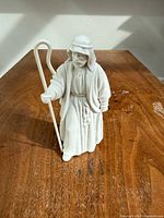 front view of white porcelain shepherd figurine holding crook