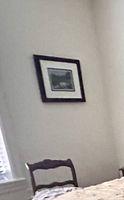 Framed photo on wall showing scale relative to chair