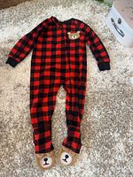 Full front view of footed sleeper showing plaid pattern, zipper, bear appliqué, and foot graphics