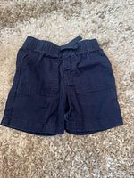 Front view of navy cotton shorts showing elastic waistband, drawstring and front patch pockets