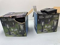 Two original boxes labeled Solar LED pathway lights, boxes open showing contents