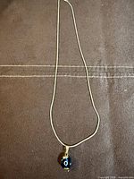 Full view of necklace laid flat showing overall length and pendant