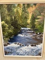 Front view of acrylic painting showing stream scene inside double mat and frame