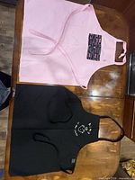 Both aprons laid flat showing overall design and colours