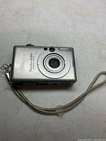 Front view of Canon PowerShot SD300 showing lens and wrist strap