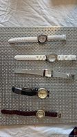 Group shot of five wrist watches laid out vertically