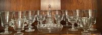 Cabinet view of 12 stem glasses flanking divided dish