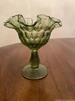 Front view of olive green thumbprint compote on table