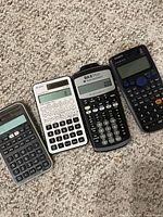 Four calculators laid out showing models and keypads