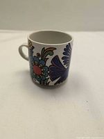 Side view of cup showing blue and purple floral design