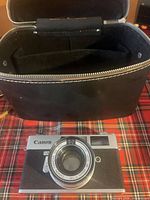 Front view of Canon rangefinder camera and black zippered carrying case
