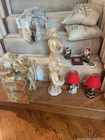 Overview showing mirrored boxes, angel figures, lamps, pillows, small figurines