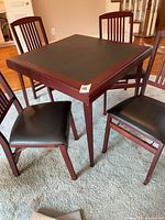 Square table with chairs around it, shows finish and upholstery