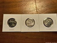 Three reverse sides of 1992 commemorative quarters in flips