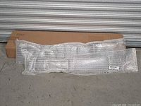 Bubble wrapped horizontal grille and mounting hardware in front of original APS box