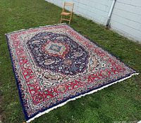Angled full view of the rug on grass with chair for scale