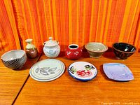 All nine pottery pieces lined in two rows