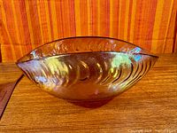 Side view showing oval form, ribbed exterior, iridescent finish