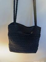 Front view showing crochet pattern, braided straps, exterior zipper pocket