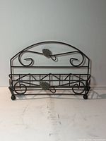 Front view of wrought iron basket showing scrollwork and leaf motif