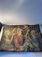 Front of woven cushion cover showing figures, bird, donkey and foliage