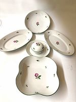Group shot of five porcelain serving pieces with pink rose pattern