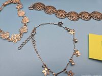 All three rose-gold tone floral bracelets laid out