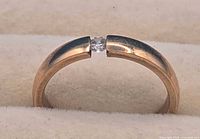 Gold-tone ring front view showing tension-set stone
