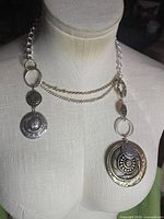 Necklace displayed on mannequin showing chain layout and pendants