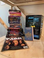 Stack of Star Trek paperback novels, Geordi La Forge model kit box, Klingon Dictionary, Star Trek magazines