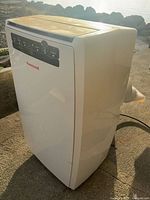 Front three-quarter view of air conditioner showing brand and side profile