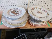 Two stacks of assorted plates and bowls showing decorative edges and patterns.