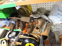 Shelf with assorted vintage irons, saw blades, food grinder, temperature faucets and clamps
