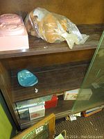 Lower shelf with blue dish and boxed items beneath shelves