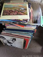 Stack of various LP vinyl records seen from above with visible covers and spines, showing many different artists and albums.