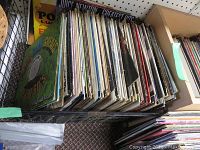 Box of LP vinyl records stacked vertically showing a large number of albums including visible Juice Newton Greatest Hits album.