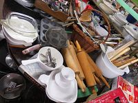 Overview of lot with rolling pins, kitchen utensils in white containers, muffin tins, and ceramic blue cornflower pot and dishes visible