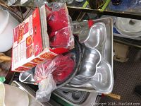 Photo showing multiple aluminum baking sheets, cake molds, silicone bakeware pieces, and the boxed My Lil' Pie Maker kit packed together.