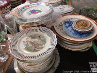 Various stacks of plates including decorative pierced edges and nature-themed prints