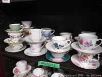Display of the 18 tea cups and saucers in multiple stacks showing different floral designs