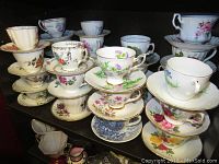 Overview photo showing stacks of teacups and saucers in various floral patterns and colors