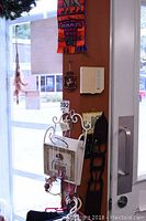 View of door area showing some dream catchers hanging, part of a decorative wreath and wall mounted letter holder with scroll design and small wooden decorative items.