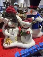 front view showing three primary plush snowmen figures