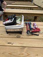 Lot overview on bench with stacked paint trays, mini rollers, caulk guns