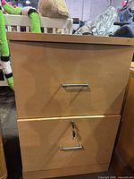 front view of two-drawer light maple filing cabinet showing handles and lock