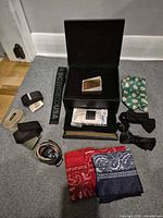 All items arranged: belts, bow ties, bandanas, wooden box, outer black case
