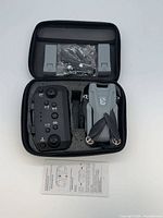 Drone, remote, batteries, and accessories seated in foam inside open carrying case